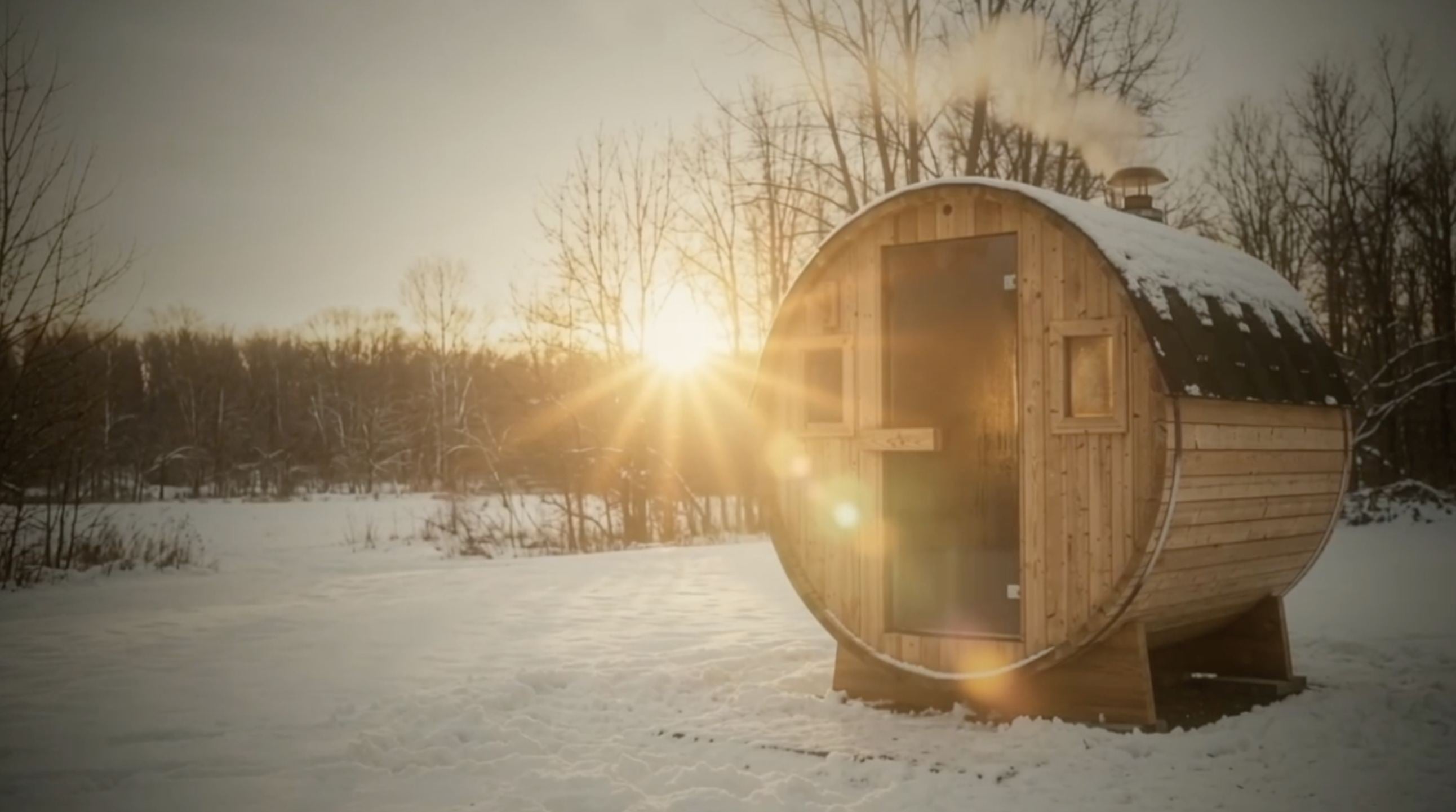 A barrel-style outdoor sauna in snow at sunset, smoke rising from its chimney.
