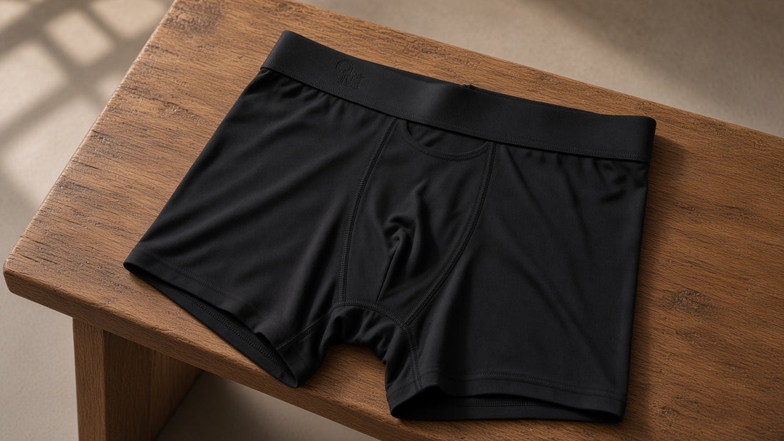 An Oakman boxer brief laid flat on a wood bench, warm diagonal light through a window.