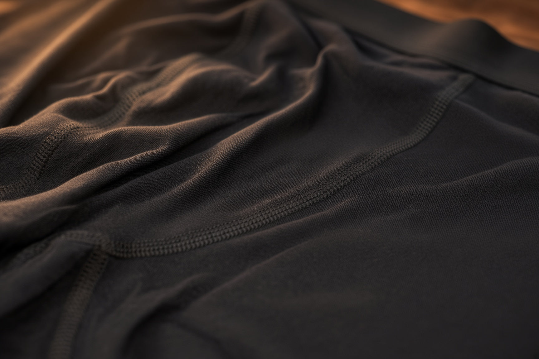 Close-up of Oakman fabric, folded dark weave with a warm light streak across it.